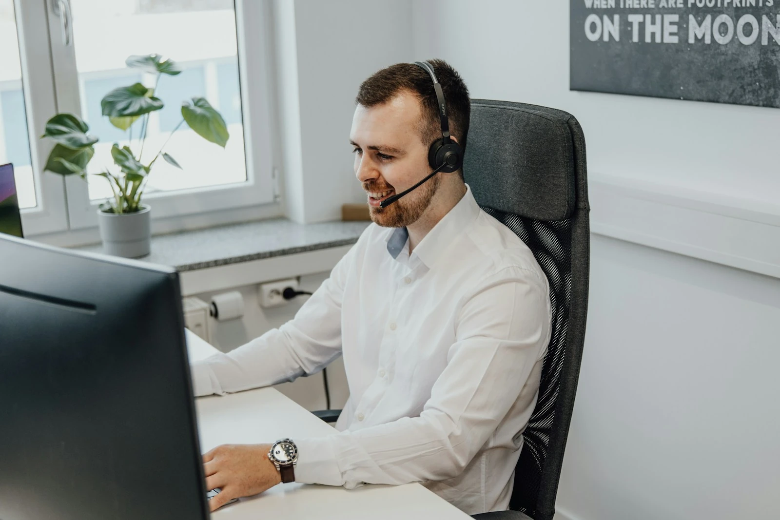 <p>a man wearing a headset sitting in front of a computer. Photo by SEO Galaxy, Unsplash.</p>